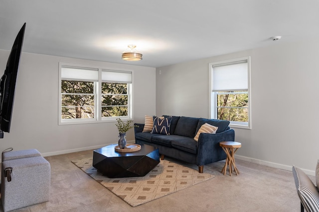 living room with carpet floors, a healthy amount of sunlight, and baseboards