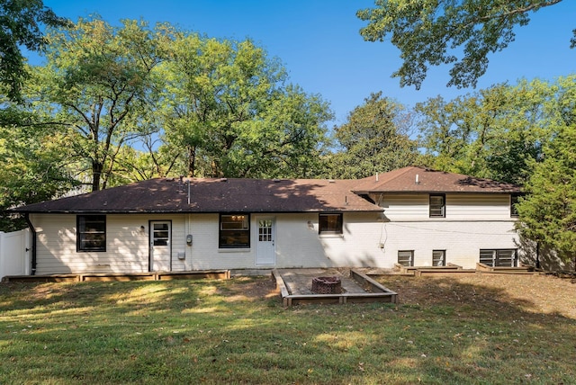 back of property featuring a lawn and fence