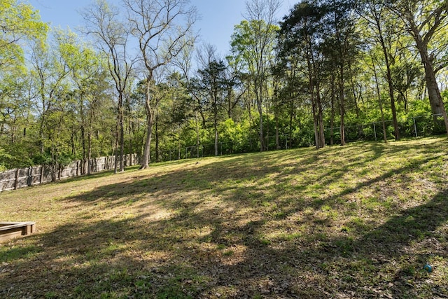 view of yard with a fenced backyard and a forest view