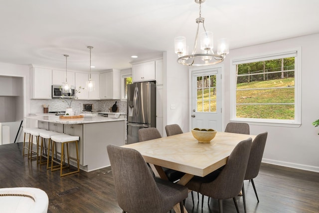 dining room featuring baseboards, visible vents, dark wood-style floors, and a notable chandelier