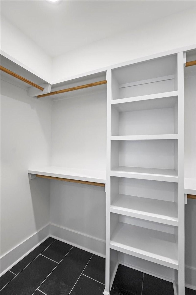 walk in closet featuring dark tile patterned floors
