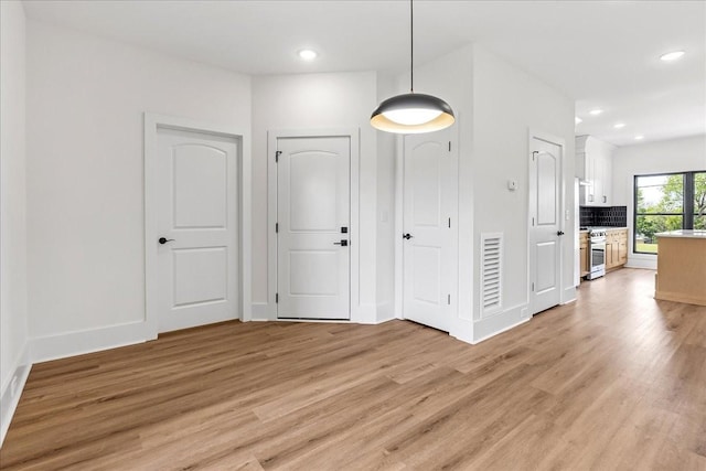interior space featuring visible vents, baseboards, recessed lighting, and light wood-style floors