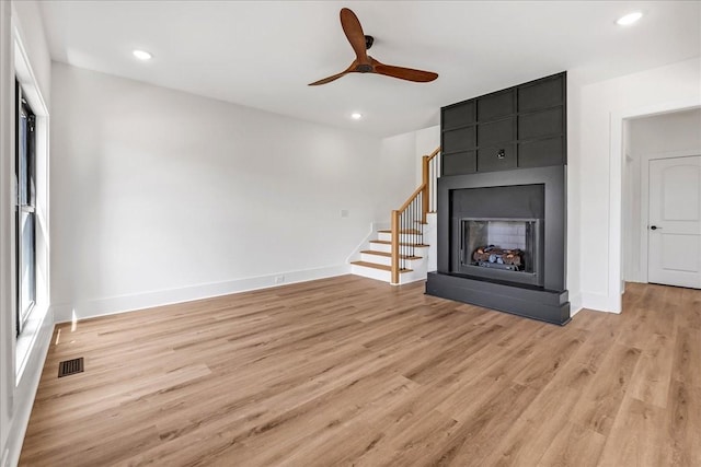 unfurnished living room with recessed lighting, light wood-style flooring, visible vents, and a multi sided fireplace