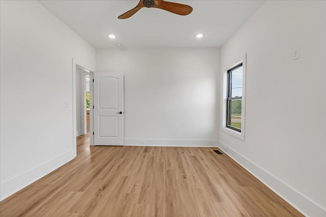 spare room with light wood-type flooring, visible vents, baseboards, and a healthy amount of sunlight