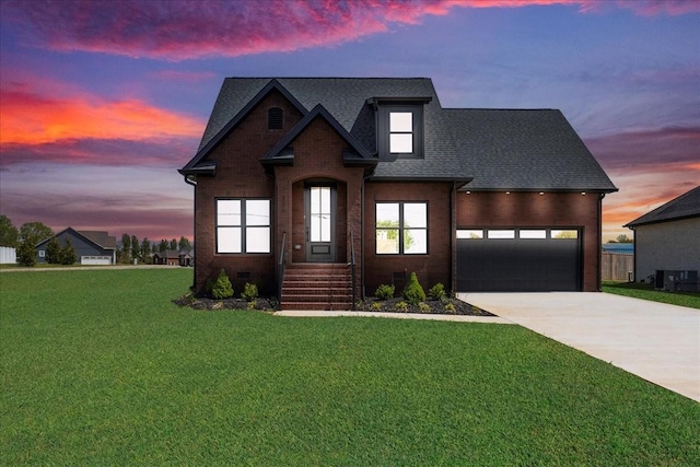 view of front facade with roof with shingles, driveway, brick siding, an attached garage, and a lawn