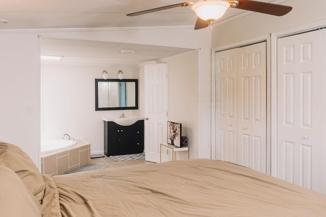 1005 Chris Dr, Portland, TN 37148 - bedroom featuring a sink, two closets, light tile patterned floors, and crown molding