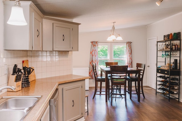 1005 Chris Dr, Portland, TN 37148 - kitchen with stainless steel dishwasher, a sink, decorative backsplash, light countertops, and dark wood-type flooring