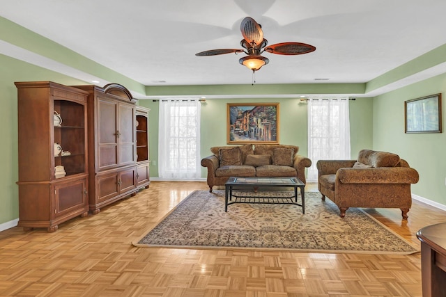 living area with plenty of natural light, baseboards, and ceiling fan