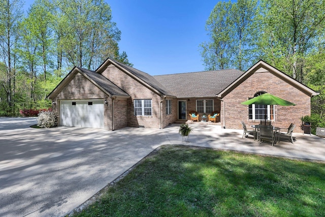 ranch-style house featuring brick siding, driveway, a shingled roof, and a garage