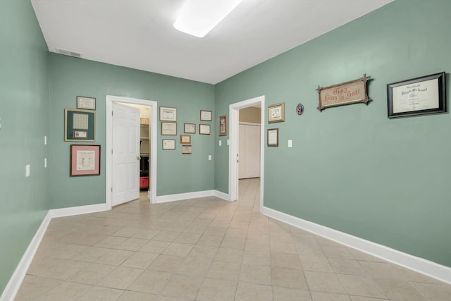 spare room with baseboards, visible vents, and light tile patterned floors
