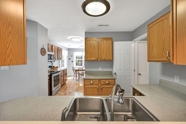 kitchen featuring light countertops, visible vents, stainless steel appliances, and a sink