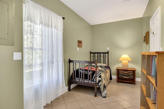 bedroom with lofted ceiling, baseboards, and light tile patterned floors