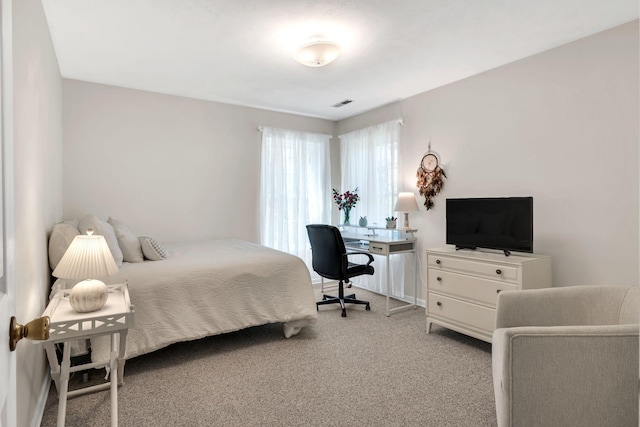 bedroom with visible vents and light carpet