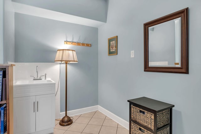 interior space with light tile patterned floors, baseboards, and a sink