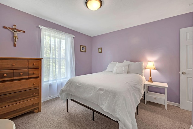 bedroom featuring light colored carpet and baseboards