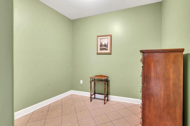 unfurnished room with light tile patterned flooring and baseboards