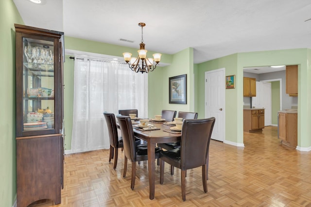 dining space featuring baseboards, visible vents, and an inviting chandelier