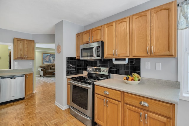 kitchen featuring appliances with stainless steel finishes, tasteful backsplash, and light countertops