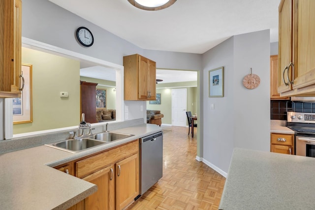 kitchen featuring a sink, baseboards, decorative backsplash, light countertops, and appliances with stainless steel finishes