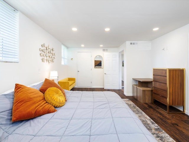 bedroom featuring baseboards, wood finished floors, visible vents, and recessed lighting