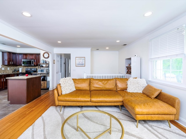 living area with crown molding, wood finished floors, baseboards, visible vents, and recessed lighting