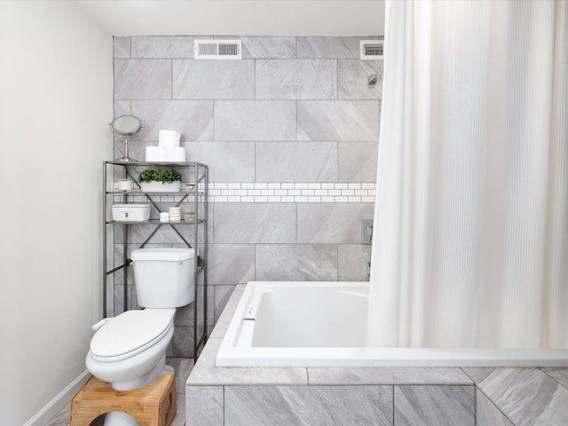 full bathroom with visible vents, toilet, and tiled tub