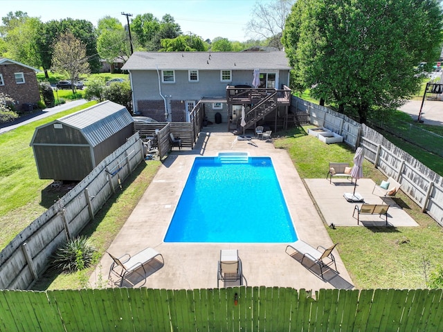 view of swimming pool featuring stairway, a fenced backyard, a patio, a lawn, and a deck