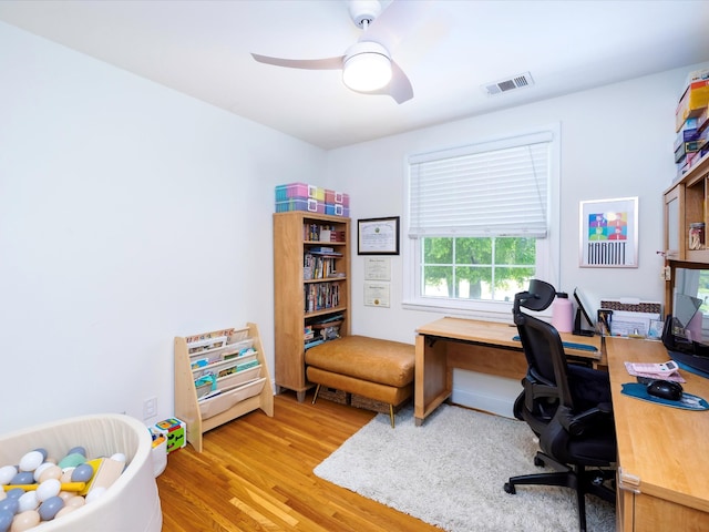 office area with wood finished floors, visible vents, and a ceiling fan