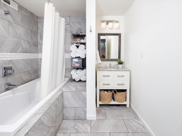 bathroom with baseboards, visible vents, marble finish floor, tiled shower / bath combo, and vanity