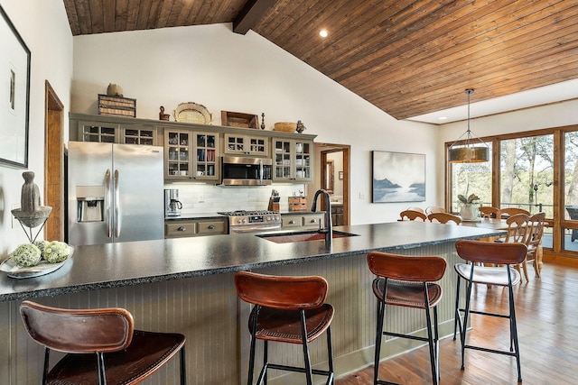kitchen featuring dark countertops, a sink, light wood-style floors, wood ceiling, and stainless steel appliances