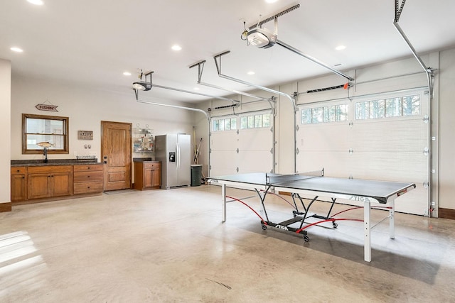 rec room featuring a garage, recessed lighting, and finished concrete flooring