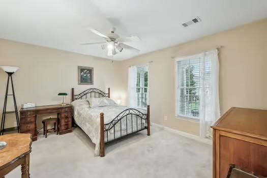 bedroom featuring light colored carpet, baseboards, and ceiling fan