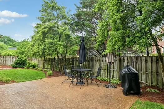 view of patio with a fenced backyard, outdoor dining space, and grilling area