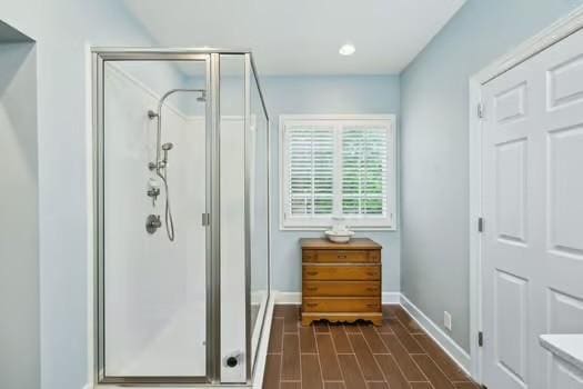 full bathroom with a stall shower, baseboards, and recessed lighting