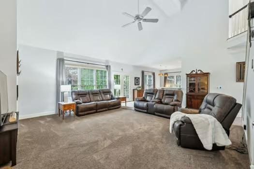 carpeted living area featuring high vaulted ceiling, ceiling fan, and baseboards