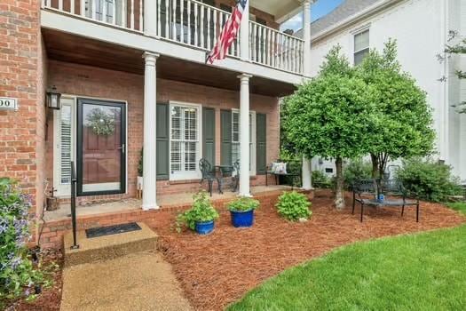entrance to property with a balcony and brick siding