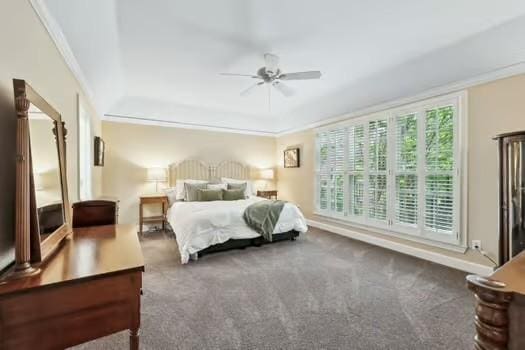 carpeted bedroom with ornamental molding, a ceiling fan, and a tray ceiling