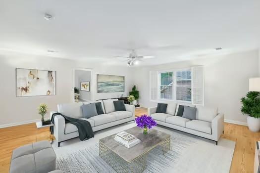 living area with baseboards, a ceiling fan, and wood finished floors