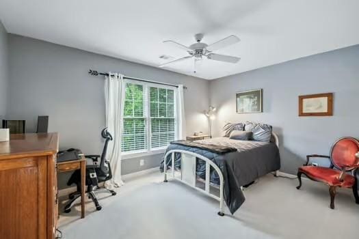 carpeted bedroom with baseboards, an office area, and ceiling fan