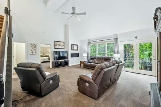 living area with high vaulted ceiling, carpet flooring, stairs, beamed ceiling, and a ceiling fan