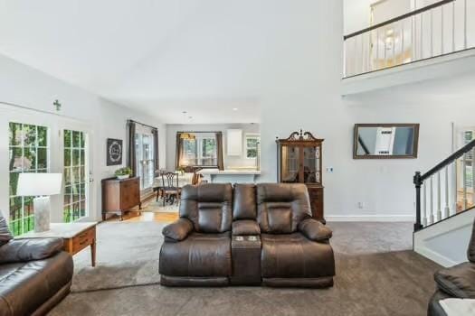 carpeted living room with stairway and baseboards