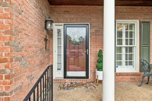 doorway to property featuring brick siding