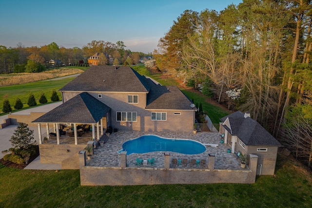 outdoor pool with a yard, a patio area, and a fenced backyard
