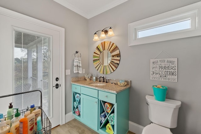 bathroom featuring wood finished floors, vanity, baseboards, toilet, and ornamental molding