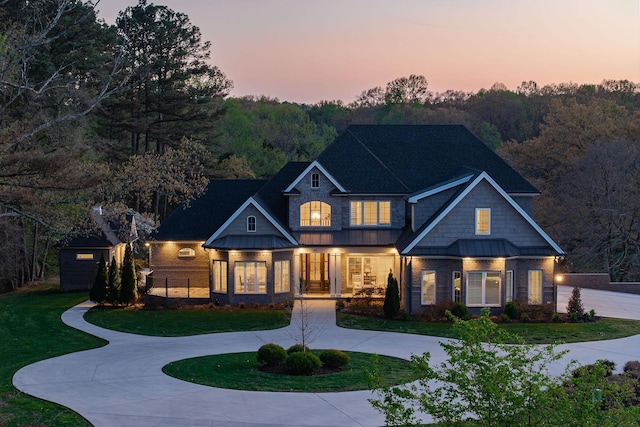 view of front of home featuring a standing seam roof, curved driveway, and metal roof