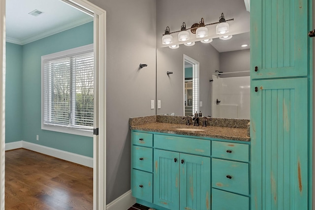 bathroom featuring baseboards, crown molding, visible vents, and a healthy amount of sunlight