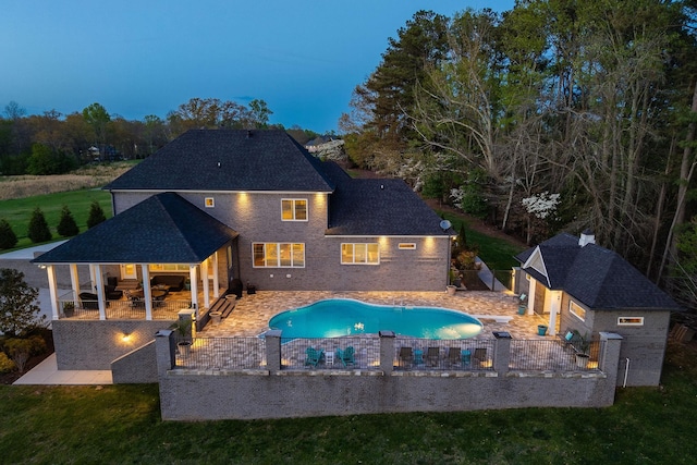 view of pool with an outdoor structure, a patio area, a fenced in pool, and a fenced backyard