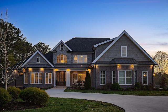 view of front facade featuring a standing seam roof, a yard, and metal roof