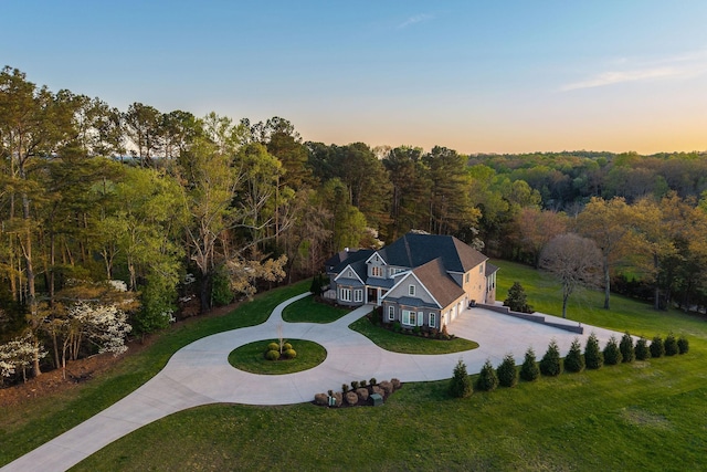 bird's eye view with a wooded view