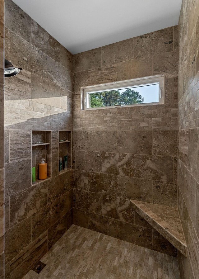 full bathroom with a healthy amount of sunlight and tiled shower